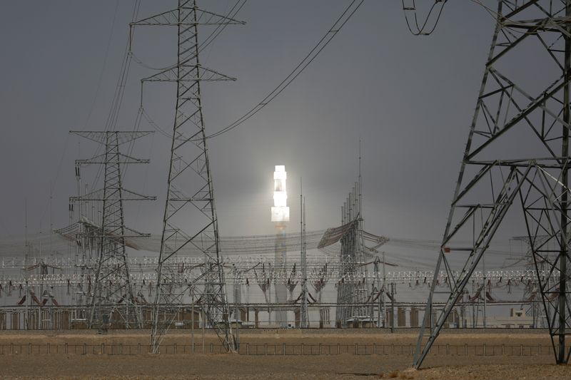 &copy; Reuters. A molten salt solar tower stands behind electricity pylons at a power station near Dunhuang, Gansu province, China April 13, 2021. Picture taken April 13, 2021. REUTERS/Carlos Garcia Rawlins