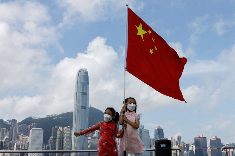 &copy; Reuters. 　１月１３日、中国外務省の香港出先機関は英政府に対して、香港に関する報告書を廃止するよう求めた。写真は中国の旗を持って国慶節を祝う子供。香港で昨年１０月撮影（２０２３年　