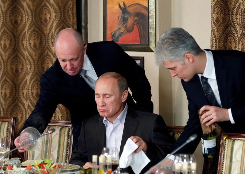 &copy; Reuters. FILE PHOTO: Yevgeny Prigozhin (L) assists Russian Prime Minister Vladimir Putin during a dinner with foreign scholars and journalists at the restaurant Cheval Blanc on the premises of an equestrian complex outside Moscow November 11, 2011. Picture taken N