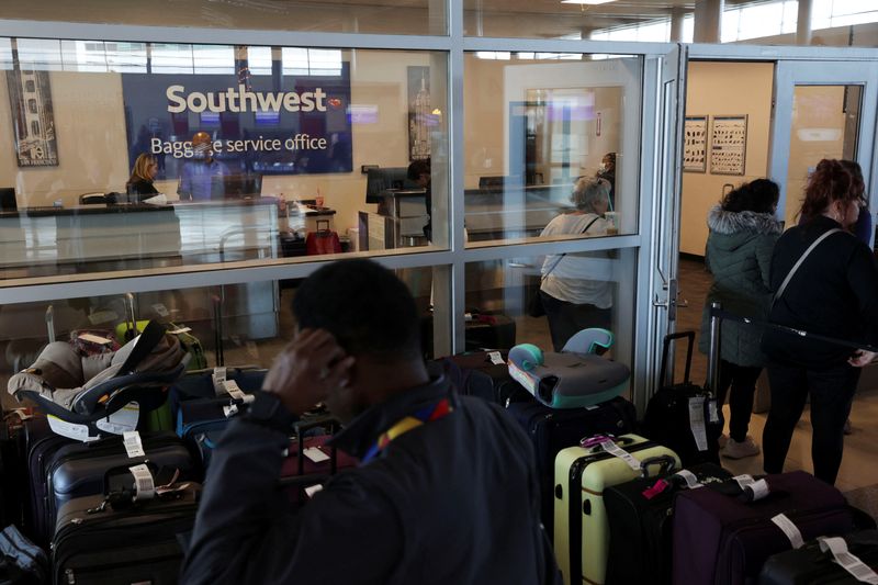 &copy; Reuters. Southwest Airlines passengers wait in line at the baggage services office after U.S. airlines, led by Southwest, canceled thousands of flights due to a massive winter storm which swept over much of the country before and during the Christmas holiday weeke