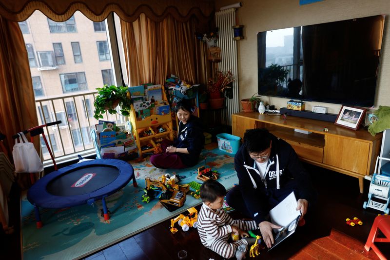 &copy; Reuters. Ang Ran e Tang Huajun brincam com filho de 2 anos Tang Ziang dentro de sua casa em Pequim
08/11/2022
REUTERS/Tingshu Wang