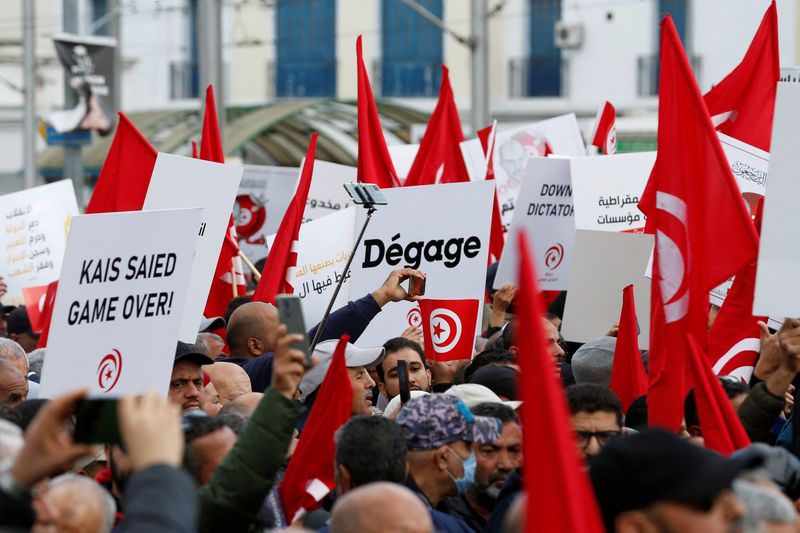 &copy; Reuters. Demonstrators hold placards during a protest against Tunisian President Kais Saied, on the anniversary of the 2011 uprising, in Tunis, Tunisia January 14, 2023. REUTERS/Zoubeir Souissi