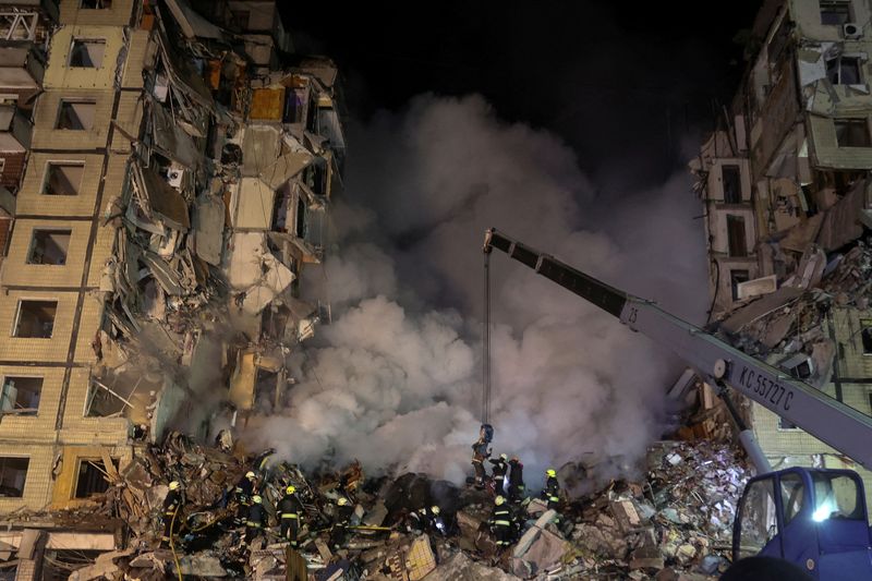 &copy; Reuters. عمال الإنقاذ يعملون على إنقاذ سكان مبنى سكني في مدينة دنيبرو الأوكرانية بعد سقوط قذيفة صاروخية روسية عليه يوم السبت. تصوير: ييفهين تيتوف - رو