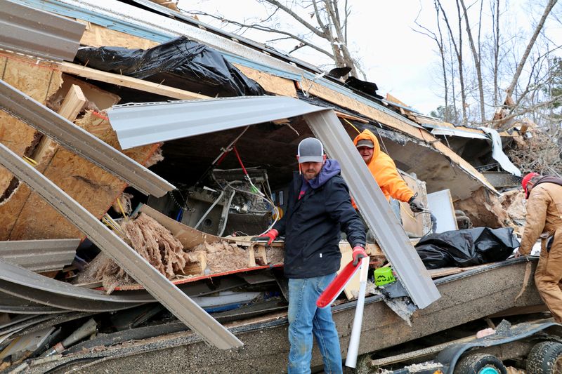 © Reuters. Family and friends of Justin and Amber Wallace help clean up the damage to their home that was destroyed after a tornado, in Deatsville, Alabama, U.S., January 13, 2023. REUTERS/Evan Garcia