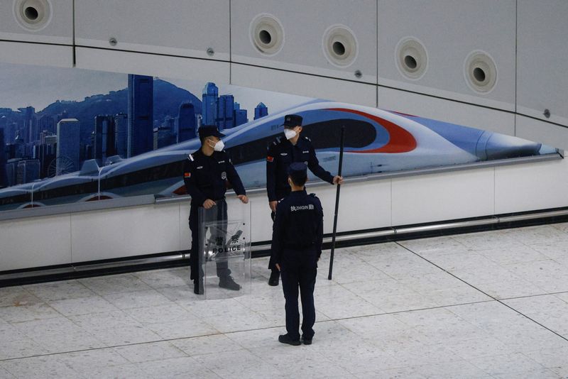 © Reuters. A Chinese police officer stands guard at in the mainland port area of West Kowloon High-Speed Train Station Terminus on the first day of the resumption of rail service to mainland China, during the coronavirus disease (COVID-19) pandemic in Hong Kong, China, January 15, 2023. REUTERS/Tyrone Siu