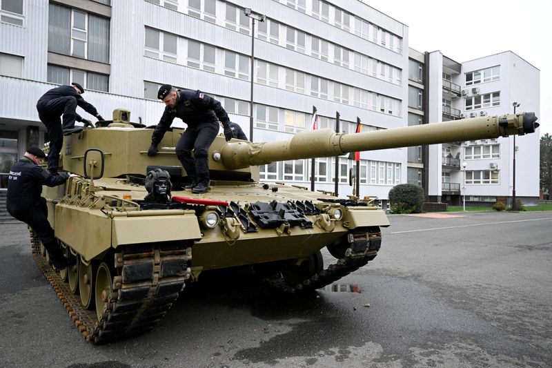 © Reuters. FILE PHOTO: Members of the military walk on a tank, as Germany delivers its first Leopard tanks to Slovakia as part of a deal after Slovakia donated fighting vehicles to Ukraine, in Bratislava, Slovakia, December 19, 2022. REUTERS/Radovan Stoklasa/File Photo