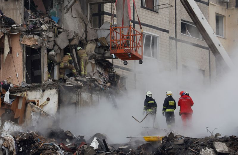 &copy; Reuters. عمال الطوارئ يعملون في موقع مبنى سكني متضرر جراء هجوم صاروخي روسي على مبنى سكني في دنيبرو بأوكرانيا يوم الأحد. تصوير: كلودا كيلكوين - رويترز. 