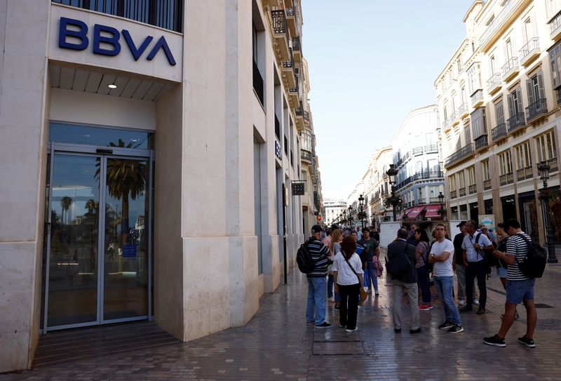 &copy; Reuters. FILE PHOTO: People stand next to a BBVA bank branch office in Malaga, Spain October 27, 2022. REUTERS/Jon Nazca/File Photo