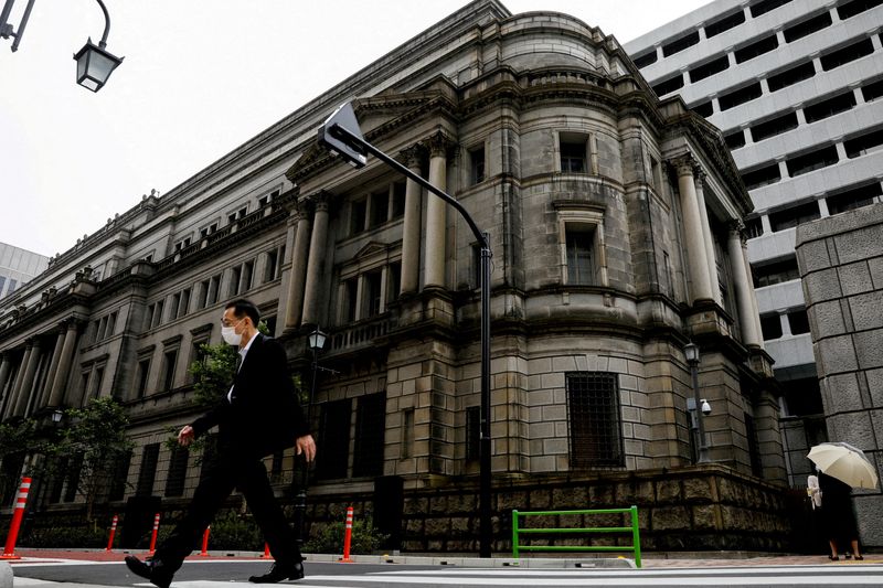 &copy; Reuters. FILE PHOTO: A man wearing a protective mask walks past the headquarters of Bank of Japan in Tokyo, Japan, May 22, 2020. REUTERS/Kim Kyung-Hoon/File Photo