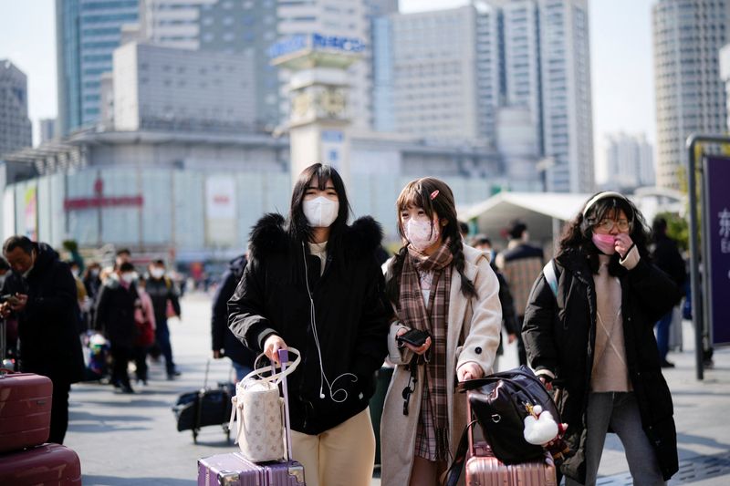 © Reuters. People walk with their luggage at a railway station during the annual Spring Festival travel rush ahead of the Chinese Lunar New Year, as the coronavirus disease (COVID-19) outbreak continues, in Shanghai, China January 16, 2023. REUTERS/Aly Song