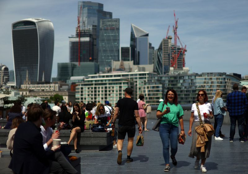 © Reuters. FILE PHOTO: People enjoy warm weather in front of the city of London financial district in London, Britain, May 18, 2022. REUTERS/Hannah McKay