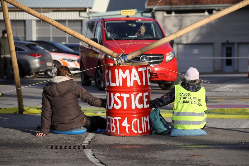 &copy; Reuters. اثنان من نشطاء المناخ يغلقون مطارا بالقرب من التنراين بسويسرا يوم الاثنين. صورة لرويترز (يحظر إعادة بيع الصورة أو الاحتفاظ بها في الارشيف.)