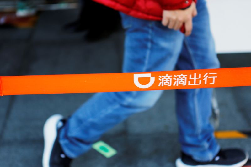 &copy; Reuters. Um homem passa por um logotipo da Didi na sede da Didi Chuxing, em Pequim, China. 20/11/2020. REUTERS/Florence Lo/Files