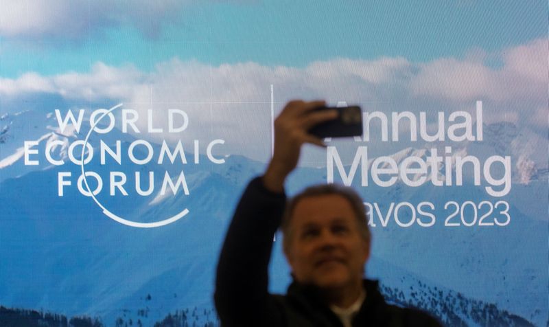 &copy; Reuters. FILE PHOTO: A man takes a selfie in front of the logo of the World Economic Forum (WEF) 2023 at Davos Congress Centre in the Alpine resort of Davos, Switzerland, January 15, 2023. REUTERS/Arnd Wiegmann