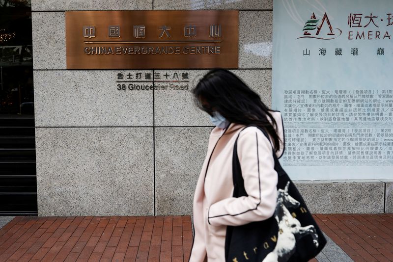 © Reuters. A woman walks in front of the China Evergrande Centre building sign in Hong Kong, China December 7, 2021. REUTERS/Tyrone Siu/Files