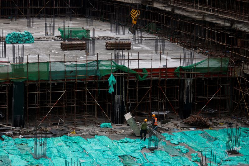 © Reuters. Workers work at a construction site in Beijing, China January 12, 2023. REUTERS/Tingshu Wang