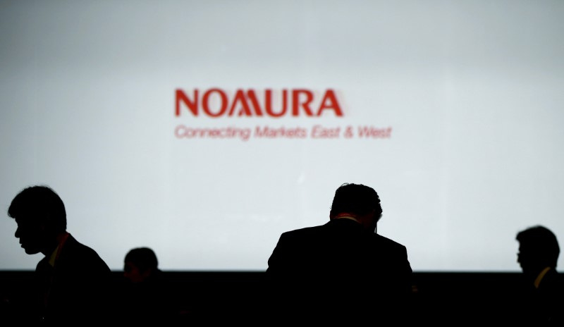 © Reuters. FILE PHOTO: Investors stand in front of a screen showing the logo of Nomura Holdings in Tokyo, Japan, December 1, 2015.  REUTERS/Toru Hanai