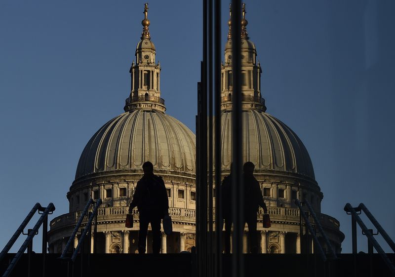 &copy; Reuters. A worker descends steps near the Millenium Bridge, with St. Paul's Cathedral seen behind during the morning rush hour in the City of London, December 16, 2014. REUTERS/Toby Melville/Files