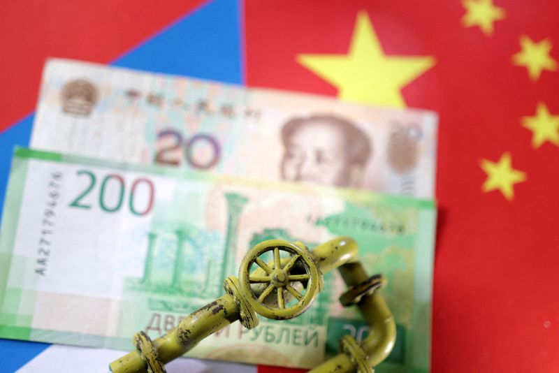 &copy; Reuters. Una miniatura di un gasdotto sopra a banconote in rubli russi e yuan cinesi. REUTERS/Dado Ruvic/
