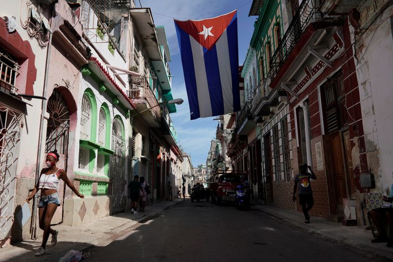 © Reuters. FILE PHOTO: People walk under a Cuban flag hanging in downtown Havana, Cuba, October 8, 2021. REUTERS/Alexandre Meneghini