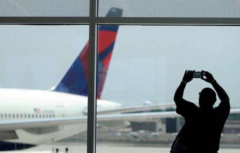 © Reuters. FILE PHOTO: A Delta employee takes a picture of Delta Airlines Flight 295 to Tokyo, Japan at the newly opened Maynard H. Jackson Jr. International Terminal at Hartsfield-Jackson Atlanta International Airport in Atlanta, Georgia May 16, 2012.  REUTERS/Tami Chappell/File Photo