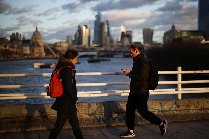 &copy; Reuters. FILE PHOTO: People walk across Waterloo Bridge with the City of London financial district in the background, in London, Britain, January 13, 2023. REUTERS/Henry Nicholls