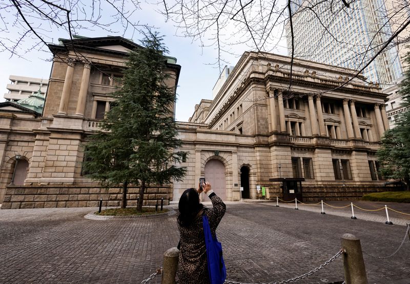 &copy; Reuters. A woman using her smartphone takes a photo of the headquarters of Bank of Japan in Tokyo, Japan, January 17, 2023. REUTERS/Issei Kato