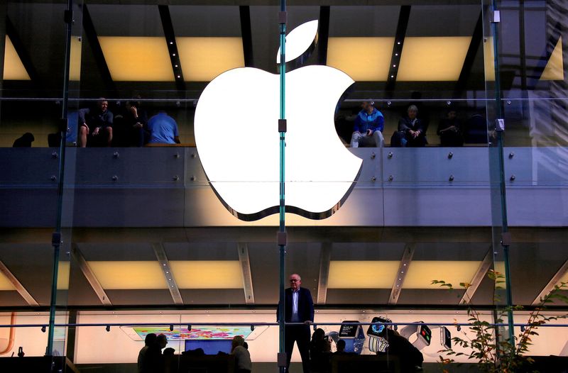 &copy; Reuters. FILE PHOTO: A customer stands underneath an illuminated Apple logo as he looks out the window of the Apple store located in central Sydney, Australia, May 28, 2018. REUTERS/David Gray/File Photo