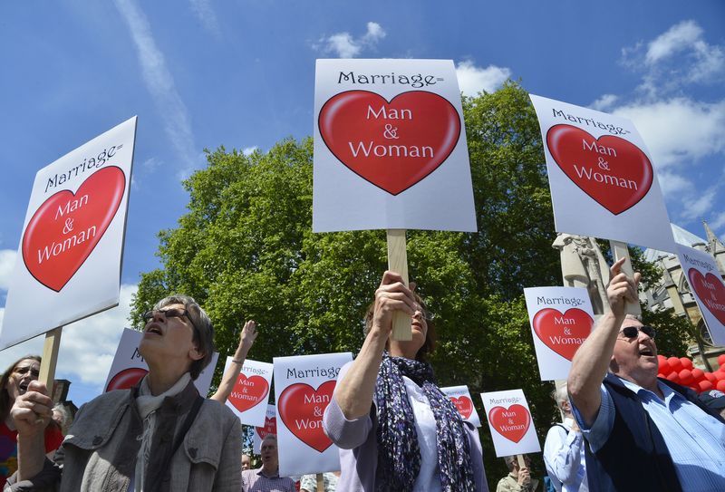 &copy; Reuters. Demonstrators protesting against a gay marriage bill hold placards outside of the Houses of Parliament in London June 3, 2013. REUTERS/Toby Melville/File Photo