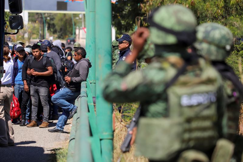 © Reuters. Mexican authorities keep watch as migrants descend from a tractor-trailer where they were transported to the U.S. at a checkpoint in Chiapa de Corzo, in Chiapas state, Mexico January 18, 2023. REUTERS/Jacob Garcia