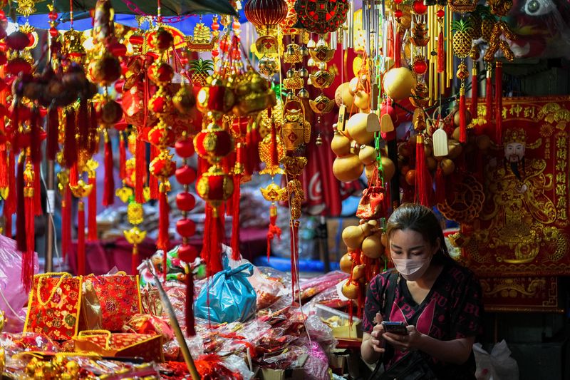 &copy; Reuters. Una donna in un negozio in attesa del Capodanno lunare nel quartiere di Chinatown a Bangkok, in Thailandia. REUTERS/Athit Perawongmetha