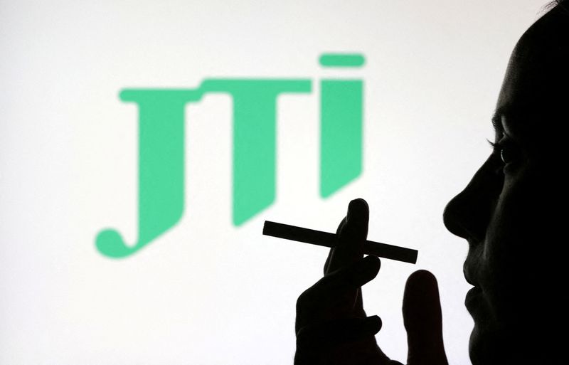 &copy; Reuters. FILE PHOTO: A woman poses with a cigarette in front of JTI (Japan Tobacco) logo in this illustration taken July 26, 2022. REUTERS/Dado Ruvic/Illustration/File Photo