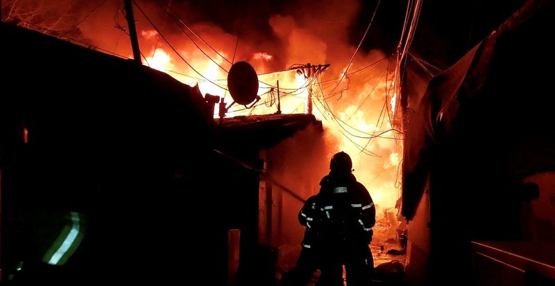 © Reuters. Firefighters work to put out the fire at Guryong village, the last slum in Seoul's glitzy Gangnam district in Seoul, South Korea, January 20, 2023. South Korea's National Fire Agency/Yonhap via REUTERS   