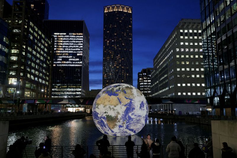 &copy; Reuters. FILE PHOTO: People look at Luke Jerram's 'Floating Earth', an installation as part of the Canary Wharf Winter Lights festival in the financial district in London, Britain, January 17, 2023. REUTERS/Kevin Coombs/File Photo