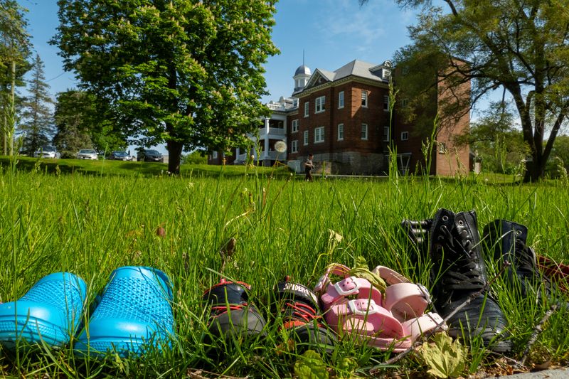 © Reuters. FILE PHOTO: Children's shoes are pictured outside the Mohawk Institute, a residential school for indigenous children that operated for 136 years, during the planting of commemorative apple trees on the former grounds which is now the Mohawk Village Memorial Park in Brantford, Ontario, Canada May 24, 2022.  REUTERS/Carlos Osorio/File Photo