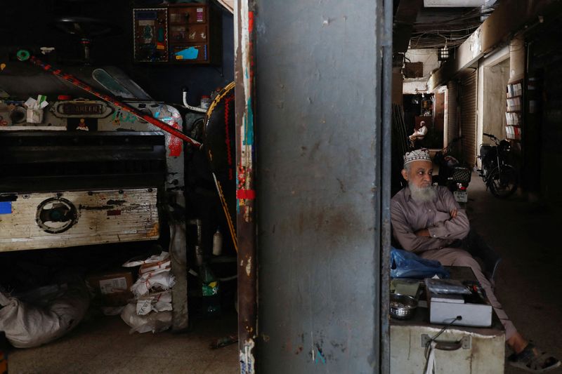 © Reuters. A man sits outside his shop during a country-wide power breakdown in Karachi, Pakistan January 23, 2023. REUTERS/Akhtar Soomro