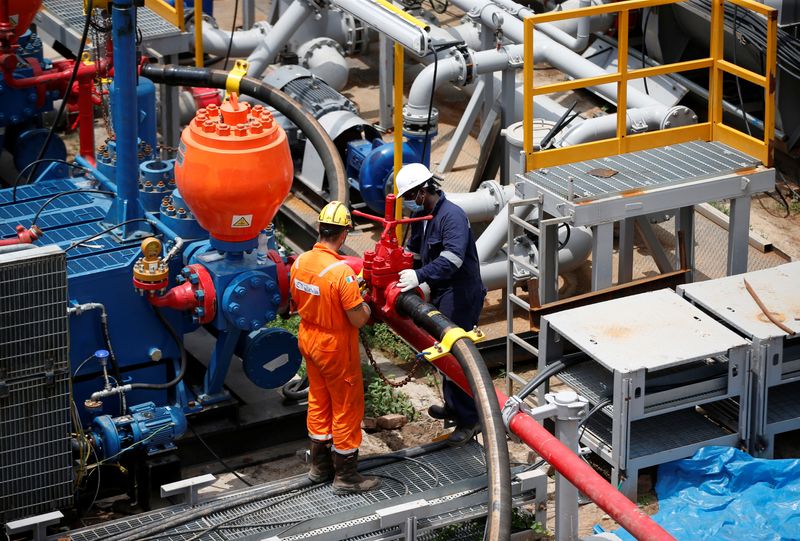 &copy; Reuters. FOTO DE ARCHIVO: Técnicos trabajan en una plataforma petrolífera fabricada por Megha Engineering and Infrastructures Limited (MEIL) en una planta de Oil and Natural Gas Corp (ONGC), durante una visita de los medios de comunicación a la planta en el pue