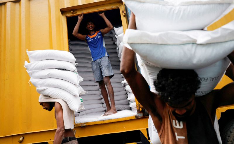 © Reuters. FILE PHOTO: Laborers carry sacks of flour in the main market as Sri Lankan President Ranil Wickremesinghe announced 2023 budget amid the country's economic crisis, in Colombo, Sri Lanka, November 14, 2022. REUTERS/ Dinuka Liyanawatte/File Photo