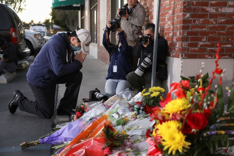 © Reuters. People mourn outside the entrance of the Star Ballroom Dance Studio after a mass shooting during Chinese Lunar New Year celebrations in Monterey Park, California, U.S. January 23, 2023. REUTERS/David Swanson