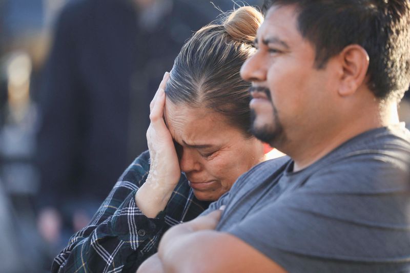 © Reuters. People mourn outside the entrance of the Star Ballroom Dance Studio after a mass shooting during Chinese Lunar New Year celebrations in Monterey Park, California, U.S. January 23, 2023. REUTERS/David Swanson