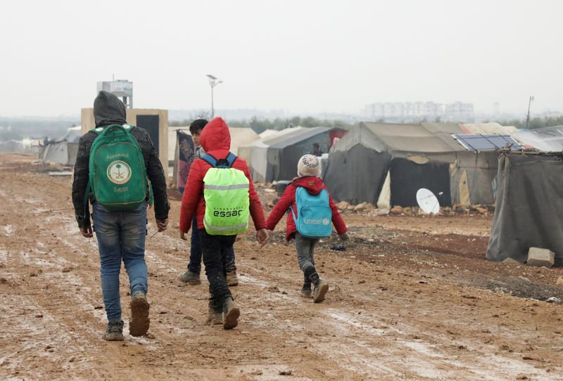 &copy; Reuters. Des Syriens déplacés marchent ensemble près de tentes dans un camp à Azaz, Syrie. /Photo prise le 1er mars 2022/REUTERS/Mahmoud Hassano
