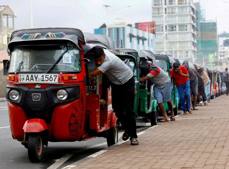 © Reuters. FILE PHOTO: Drivers push auto rickshaws in a line to buy petrol from a fuel station amid Sri Lanka's economic crisis, in Colombo, Sri Lanka, July 29, 2022. REUTERS/Kim Kyung-Hoon/File Photo