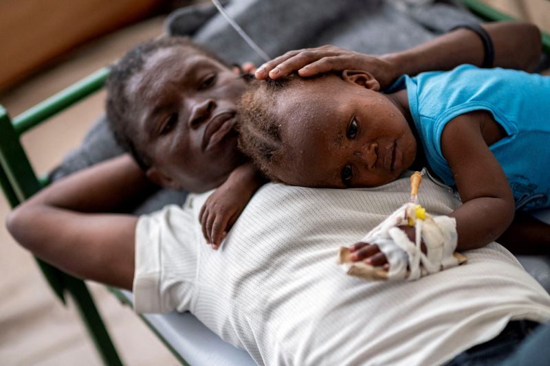 &copy; Reuters. FILE PHOTO: Karina Joseph, 19, comforts her 2-year-old child Holanda Sineus as she receives treatment for cholera in a tent at a Doctors Without Borders hospital in Cite Soleil, a densely populated commune of Port-au-Prince, Haiti October 15, 2022. REUTER