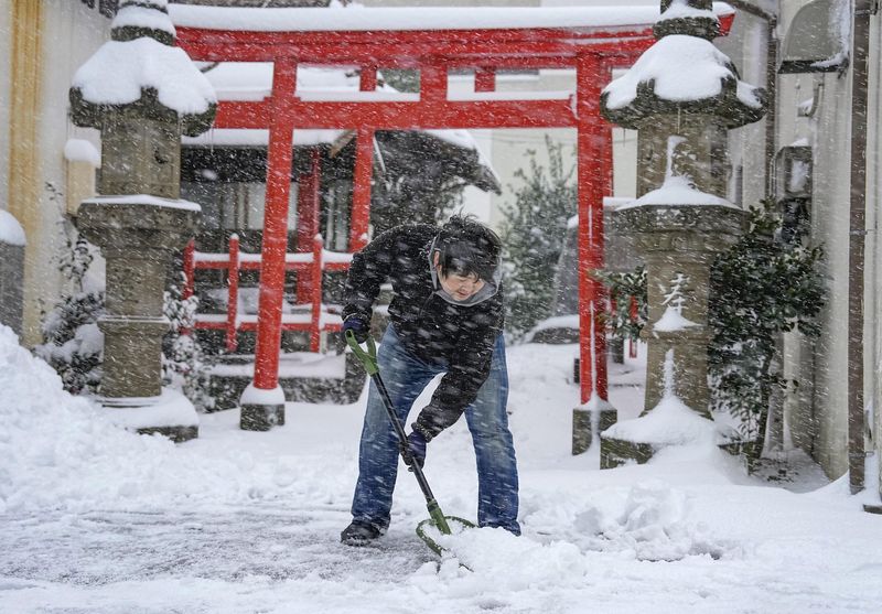 &copy; Reuters. Un homme déblaie la neige devant un sanctuaire à Tottori, au Japon. /Photo prise le 25 janvier 2023/REUTERS/Kyodo