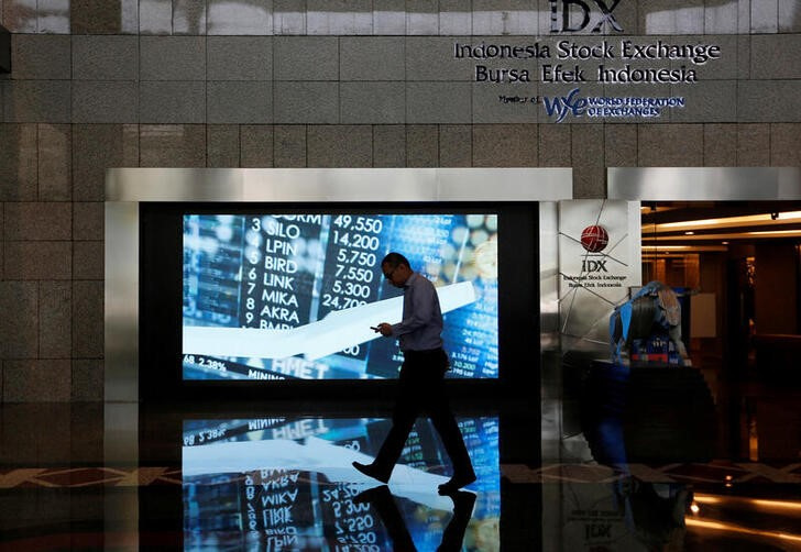 &copy; Reuters. Imagen de archivo de una personas pasando frente a una pantalla en el edificio de la Bolsa de Indonesia en Yakarta. 6 septiembre 2018. REUTERS/Willy Kurniawan