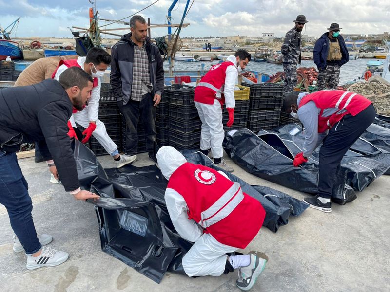 &copy; Reuters. رجال إنقاذ بالهلال الأحمر الليبي يضعون جثمان مهاجر في كيس بلاستيكي بعد غرق قارب في ليبيا يوم الثلاثاء. تصوير: رويترز.