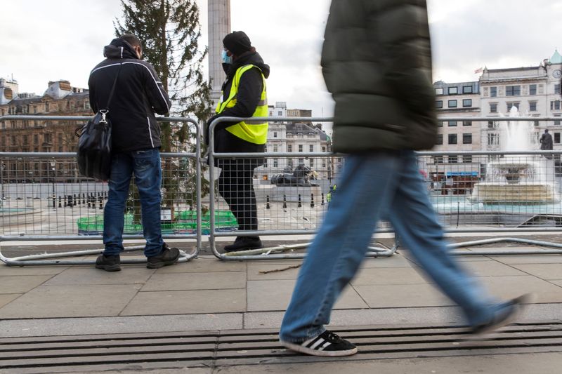 © Reuters. FILE PHOTO: A security guard stands by the temporary fencing around the perimeter of Trafalgar Square, to prevent crowds gathering on New Year's Eve, in London, Britain, December 31, 2021. REUTERS/May James