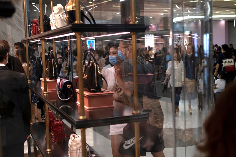 &copy; Reuters. FILE PHOTO: Customers wearing face masks following the coronavirus disease (COVID-19) outbreak, look at the products at a Gucci store, at the Sanya International Duty-Free Shopping Complex, in Sanya, Hainan province, China August 27, 2020. Picture taken A