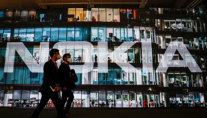 © Reuters. FILE PHOTO: People walk past a Nokia stand during GSMA's 2022 Mobile World Congress (MWC), in Barcelona, Spain February 28, 2022. REUTERS/Albert Gea/File Photo