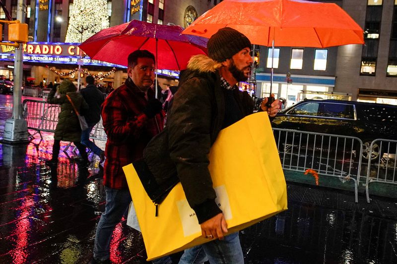 &copy; Reuters. FOTO DE ARCHIVO: Un hombre camina bajo la lluvia con una bolsa de la compra en Nueva York, Estados Unidos, el 15 de diciembre de 2022. REUTERS/Eduardo Munoz